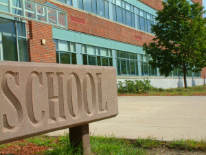 school sign with school building in the background